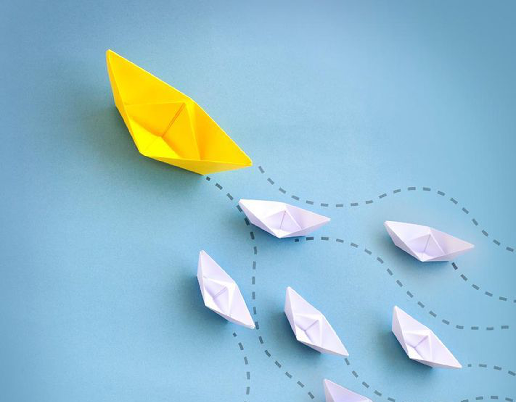 Yellow paper boat leading white boats